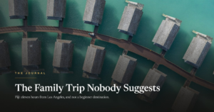 An aerial view of overwater bungalows on turquoise water, with the headline The Family Trip Nobody Suggests
